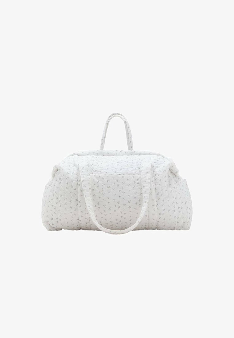 Quilted white duffle bag with subtle floral pattern, featuring two handles and a spacious design. Soft texture and rounded shape.