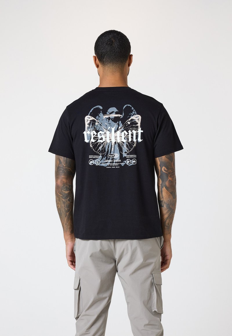 Camiseta de algodón negra con un estampado gráfico de mariposas y la palabra "resiliente" en la parte posterior. Cuello redondo, mangas cortas.