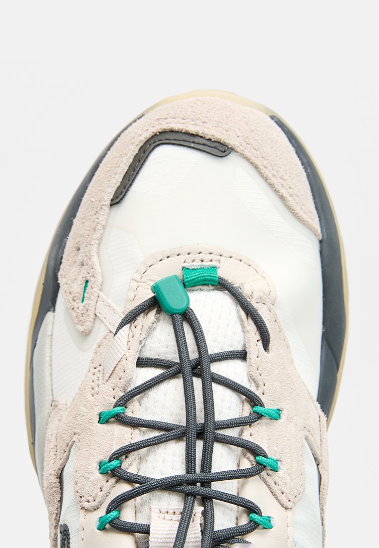 Lekkie sneakers z beżową i białą cholewką, z akcentami z zamszu, szarymi sznurówkami i turkusowymi detalami. Okrąły nosek z teksturowaną powierzchnią.