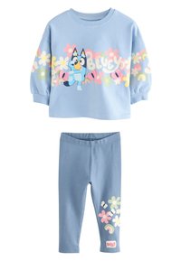 Conjunto de dos piezas azul claro que incluye una sudadera con estampados florales y un dibujo animado, combinada con leggings a juego adornados con flores.