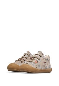 Scarpe per bambini beige con lacci, suole in gomma e stampe colorate di animali che includono dinosauri e altre creature.