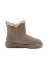 Hellbrauner Wildleder-Stiefelette mit flauschigem beigefarbenem Fellfutter, flacher Gummisohle und Zugschlaufe an der Ferse, für den Winter getragen.