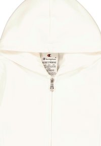 Sudadera blanca de algodón con cremallera delantera y capucha. Presenta una pequeña etiqueta de logo en el cuello interior. Adecuada para talla de 12 meses.