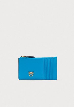 Bright blue leather cardholder with zipper pocket, three card slots, and small gold bird logo on front.