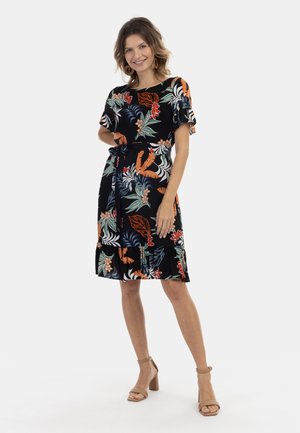 Rochie neagră cu modele florale și de frunze vibrante în roșu, portocaliu și verde. Mâneci scurte cu volănașe și o curea de legare la talie.