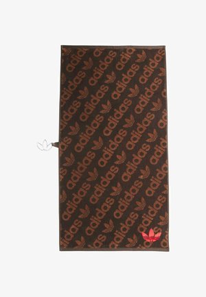 Serviette marron avec un motif intégral de l'insigne et du mot "adidas", avec un accent rouge sur un coin. Texture douce.