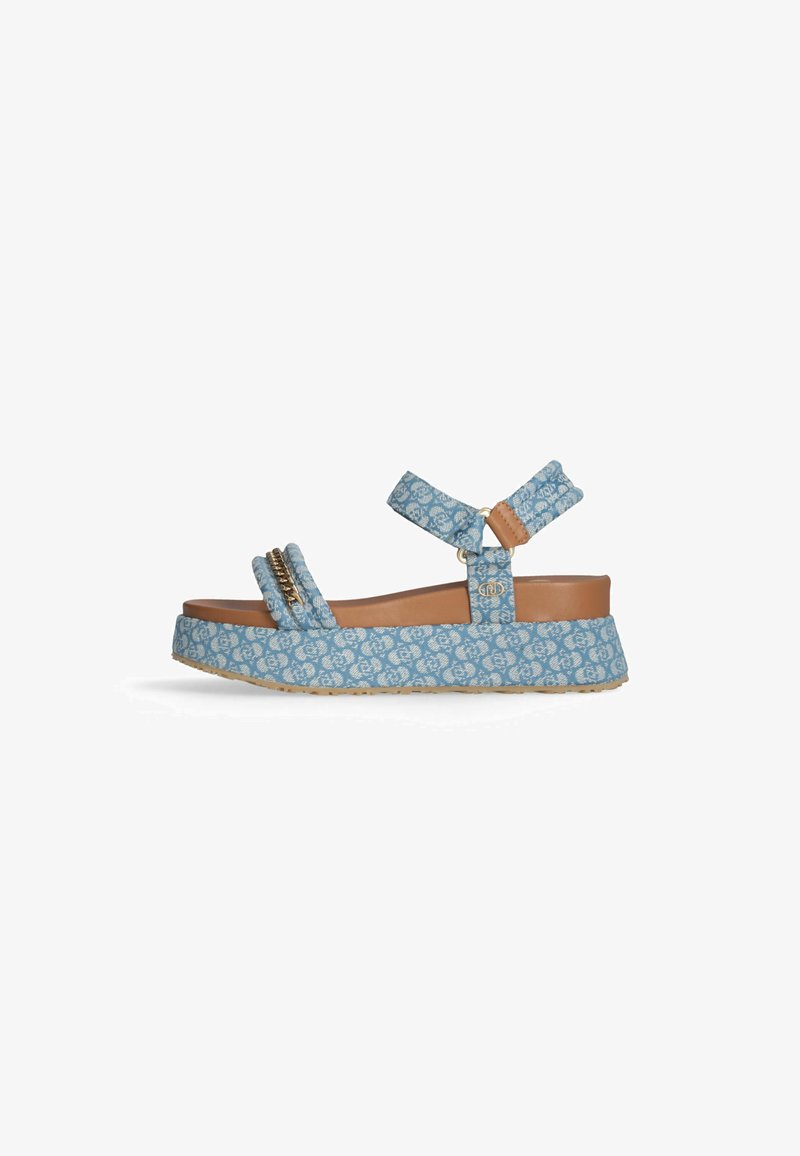 Sandalo con zeppa blu a motivo, realizzato in tessuto testurizzato, con due ampie cinghie e un accento beige. Presenta una suola spessa e una cinghia accessoria regolabile alla caviglia.