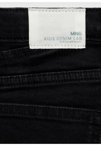 Tessuto di denim nero con un'etichetta che recita "MNG KIDS DENIM LAB." Caratteristiche includono cuciture visibili e una superficie textured.