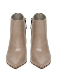 Poros toupės spalvos odiniai kulkšnių batai su smailiais noseliais ir šoninėmis užtrauktukais, parodyti iš priekio ant balto fono.