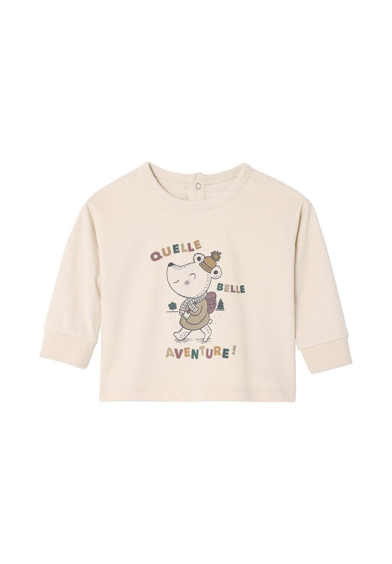 Light beige long-sleeve shirt made of soft fabric featuring a cartoon character with a backpack and text "QUELLE BELLE AVENTURE!"