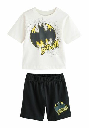 Valkoinen puuvillapaita, jossa on musta ja keltainen Batman-logo sekä roiskesuunnittelu, yhdistettynä mustiin puuvillashortseihin, joissa on keltainen logokuvio.