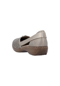 Chaussure en cuir gris clair avec un design perforé, une forme courbée et une semelle marron. Dotée d'une large sangle et d'accents de couture.