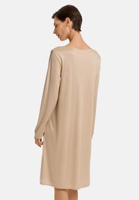 Abito beige a maniche lunghe realizzato in tessuto morbido, caratterizzato da una vestibilità comoda e un collo rotondo, che arriva fino a metà coscia.