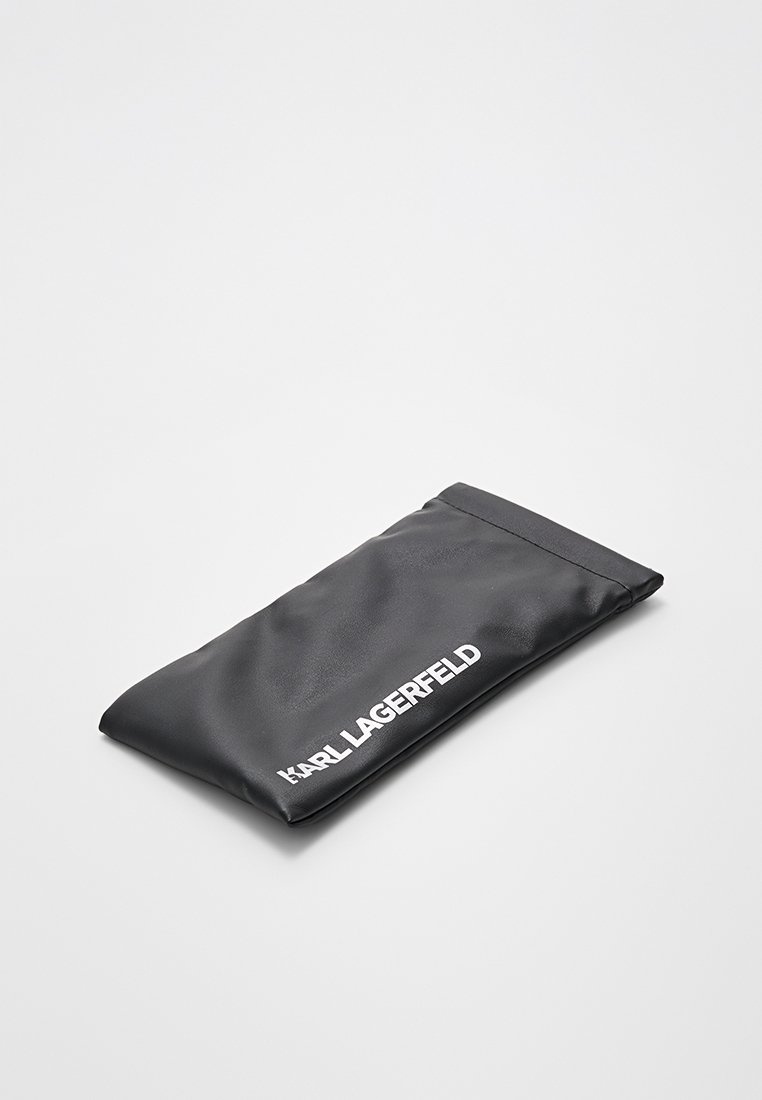 Borsa nera in tessuto morbido con una superficie liscia. Presenta una chiusura superiore e il logo "KARL LAGERFELD" in lettere bianche in grassetto. Forma rettangolare.