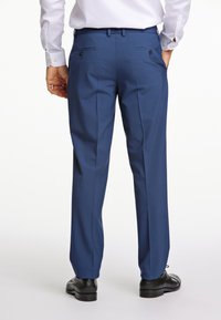 Herren Anzughose in Blau mit geradem Schnitt, verfügt über zwei Gesäßtaschen und eine glatte Textur. Kombiniert mit schwarzen Schnürschuhen.