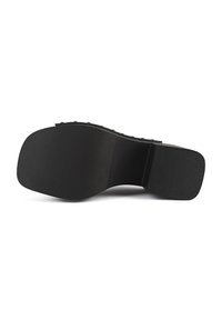 Black shoe sole made of rubber, featuring a flat textured surface with a patterned grip and smooth edges. Minimalistic design with no embellishments.
