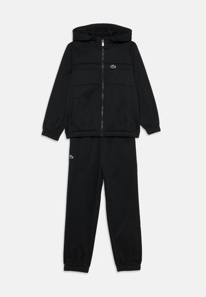 Black track suit featuring a zip-up hoodie with a kangaroo pocket and matching pants. Both have elastic cuffs and a small green logo accent.