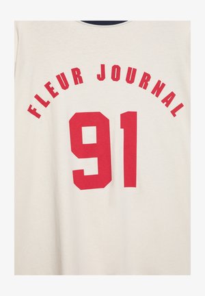 Bela tkanina z rdečim napisom "FLEUR JOURNAL", ki je lokasto postavljen nad veliko številko "91" v krepki rdeči pisavi.