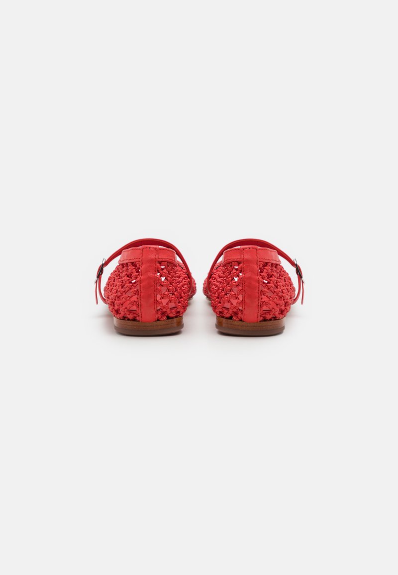 Chaussures tissées rouges avec une tige texturée, un dos ouvert, une sangle de cheville ajustable et une semelle plate couleur tan. Présente des détails complexes sur le matériau.