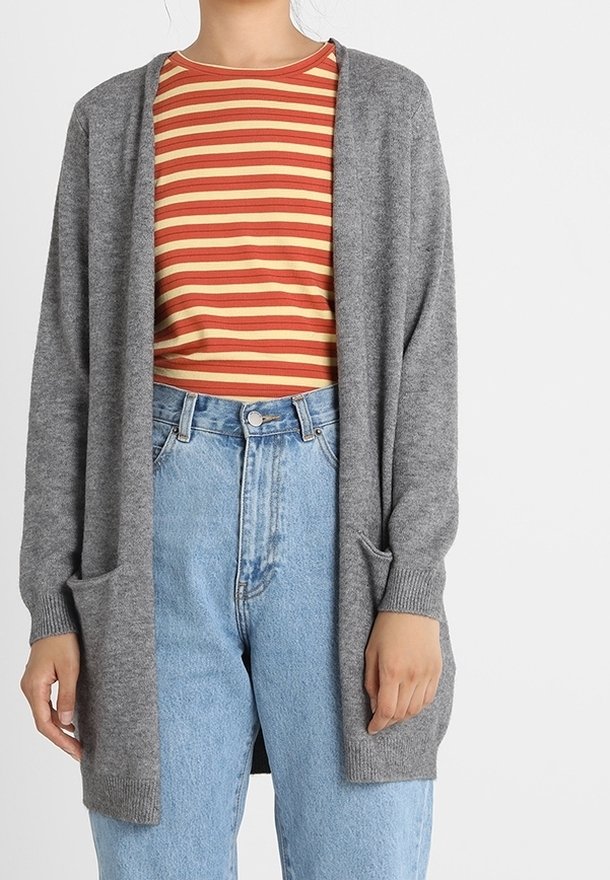 Szary sweter rozpinany na przodzie, z długimi rękawami i bocznymi kieszeniami, noszony na czerwono-żółtej pasiastej koszuli, zestawiony z wysokim stanem jeansów.