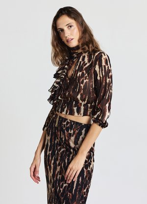 Tierdrucktop mit Rüschendetails, hoher Hals und langen Ärmeln. Farbpalette umfasst Brauntöne, Beige und Schwarz.