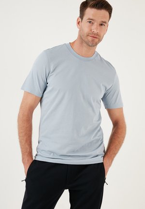 Camiseta de mangas cortas azul claro en una suave mezcla de algodón, con un cuello redondo clásico y un corte relajado. Textura suave, sin patrones visibles.