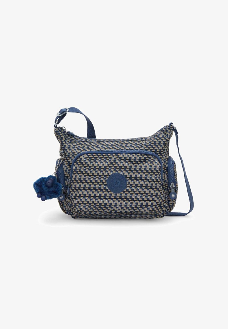 Sac bandoulière en tissu tissé bleu et beige avec une bandoulière réglable, deux poches zippées et un patch logo rond. Comprend un porte-clés pelucheux bleu.