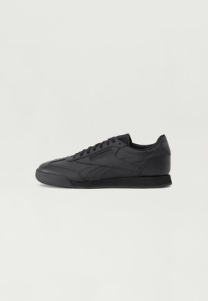 Black athletic sneakers with a smooth leather upper, low-profile design, and flat rubber sole. Features tonal stitching and lace-up closure.