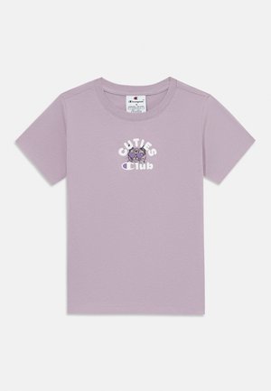 Lila pamut póló rövid ujjakkal, kerek nyakkal és elöl "CUTIES Club" feliratozással, amely egy meseábrázolást tartalmaz. Sima textúra.