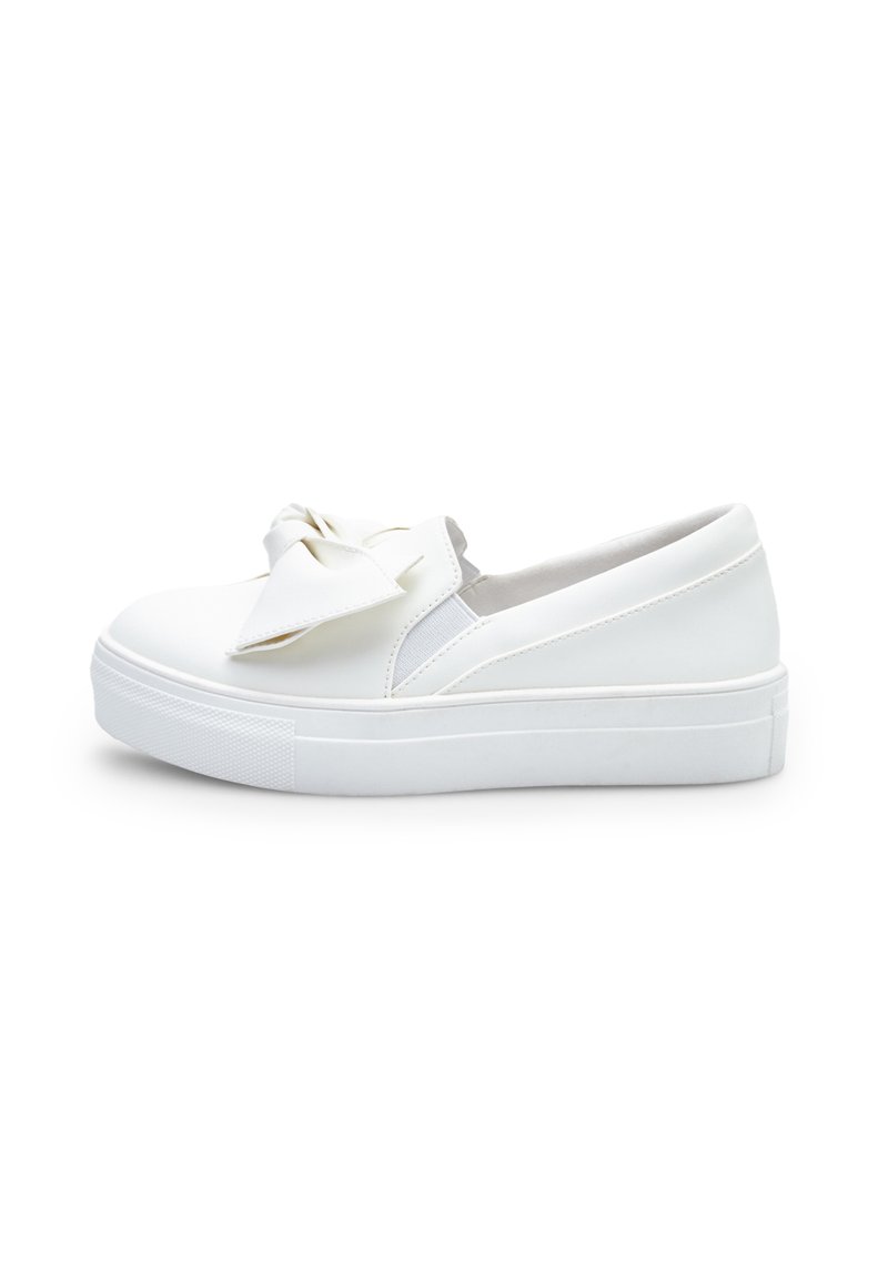 Fehér slip-on sportcipők, texturált gumitalppal, sima szintetikus felső résszel és egy nagy masni díszítéssel elöl.