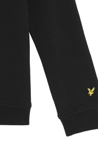 Svart sweatshirt i en blandning av bomull, med ribbade mudd och en liten gul örnlogotyp på vänster ärm.