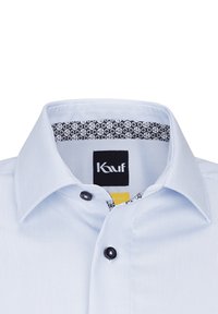 Camicia a righe blu chiaro con colletto interno nero caratterizzato da un motivo circolare. Include un bottone nero e un'etichetta del marchio.