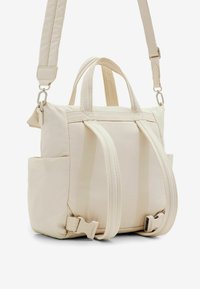 Beige nylon bag with dual top handles, removable shoulder strap, side pockets, and contrasting stitching details. Compact rectangular shape.