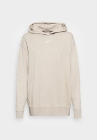 Sweat à capuche beige clair à manches longues avec petit logo Nike blanc centré sur la poitrine, présenté sur un fond blanc.