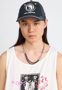 Must mustruum mustaga ja valge Billabong logo, halli õmblusega; kerge tank top graafilise printimisega; kihiline hõbedane kett.