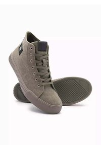 Zapatillas altas de tela verde oliva con acabado texturizado; suela de goma y diseño de cordones en tonalidad; presenta un acento de logo negro.