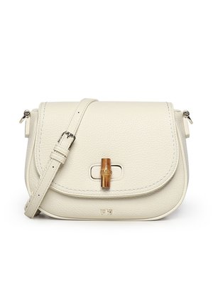 Crème-kleurige leren crossbodytas met verstelbare riem en een houten sluiting in bamboestijl op de voorklep.