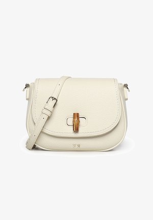 Crème-kleurige leren crossbodytas met verstelbare riem en een houten sluiting in bamboestijl op de voorklep.