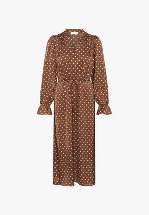 Brązowa sukienka w białe groszki z długimi rękawami, dekoltem w serek i paskiem w talii. Charakterystyczne marszczone mankiety rękawów oraz luźna, płynąca sylwetka. Miękka faktura tkaniny.