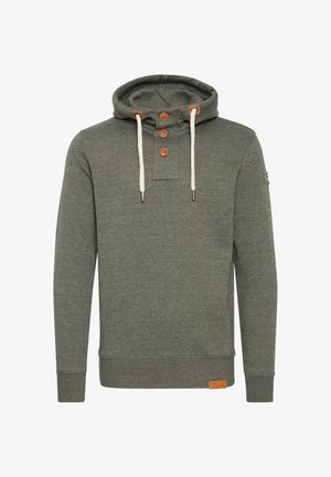 Hoodija ar kapuci izgatavota no melnzaļa auduma ar trīs koka pogām un krēmkrāsas auklām. Uz apakšējās labās malas ir uzlīme.