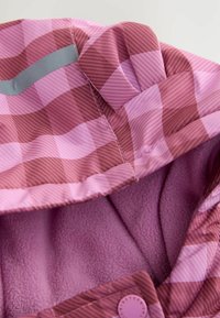 Roze geruite regenjas met een capuchon, gevoerd met zachte paarse fleece, met een grijze accent en een knoopsluiting bij de hals.