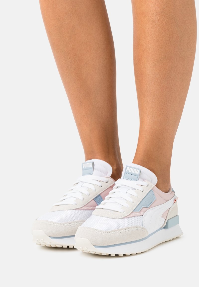 White and pastel pink athletic shoes with mesh and suede materials, a cushioned sole, and accents in light blue and red.