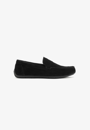 Black suede slip-on shoes with a low-profile rubber sole, featuring a rounded toe and minimal stitching detail on the upper.