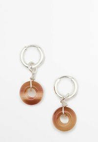 Orecchini a cerchio in argento con ciondolo circolare in resina marrone traslucida, dotato di un centro aperto, che mette in risalto un effetto colore sfumato.