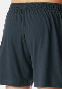 Boxer shorts neri in cotone con una vita elasticizzata, caratterizzati da una texture liscia e senza motivi o dettagli visibili.
