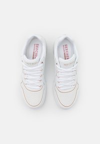 Witte sportieve sneakers met geperforeerde zijkanten, vetersluiting en roze binnenzolen. Beschikt over een subtiele rosegouden accent op het zijlogo.