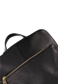 Zwarte leren tas met textuur, voorzien van een gouden ritssluiting en handvat, met een eenvoudig, modern ontwerp en een gladde voering.