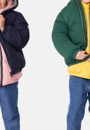 Pufferjakker i kombinasjoner av navy-rosa og grønn-gul, med elastiske mansjetter og glidelås. Bært over denimbukser.