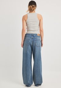 NA-KD WEITE  MIT TIEFER TAILLE - Alt laienevad teksad - vintage blue