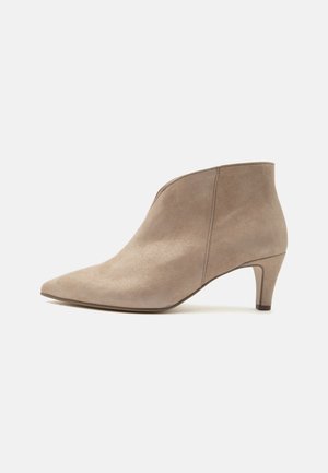 Beige suede ankle boot with pointed toe and low curved heel, showing side view on a plain white background.